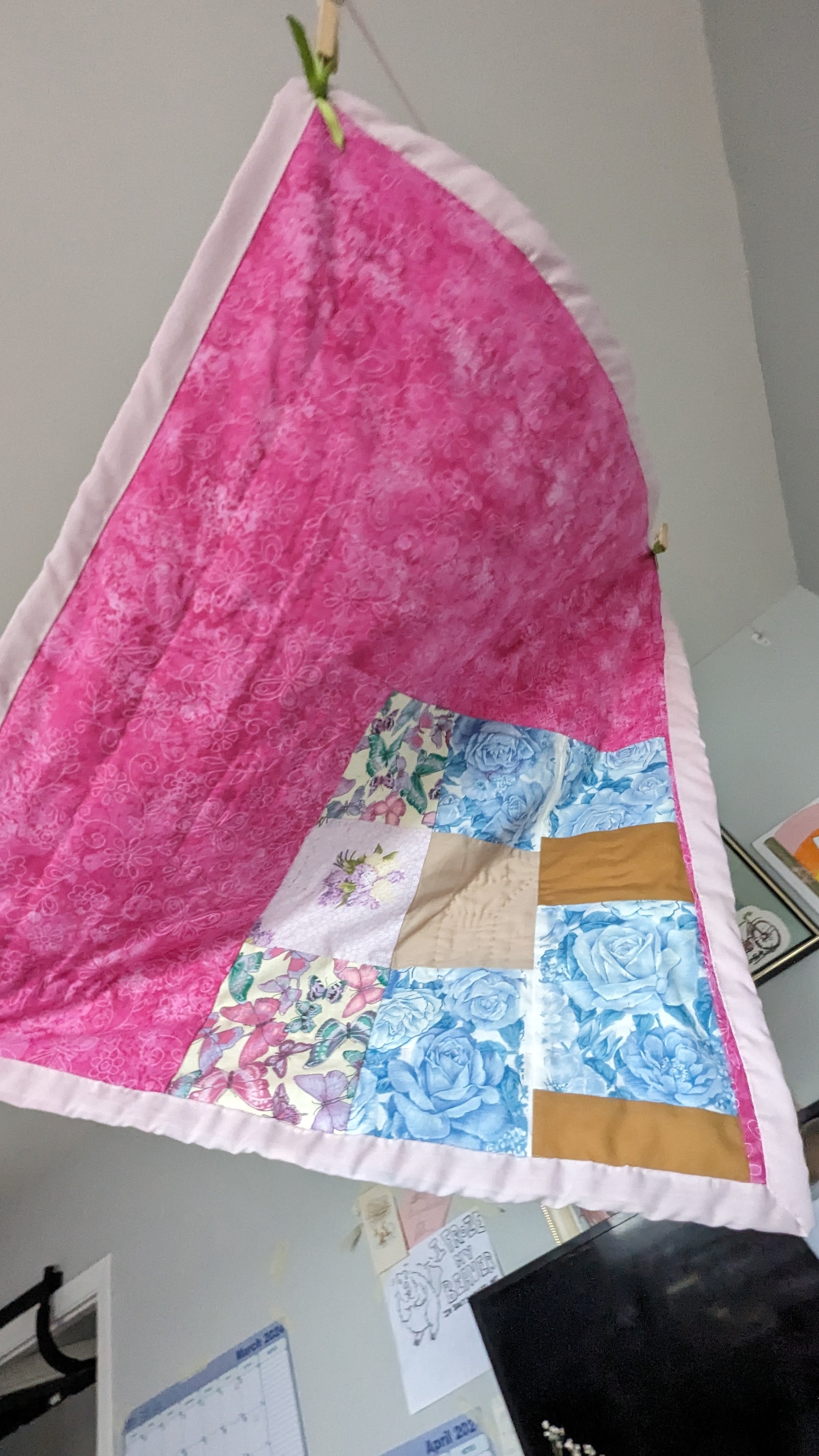 reverse side of quilt hot pink with butterflies and one quilted patch